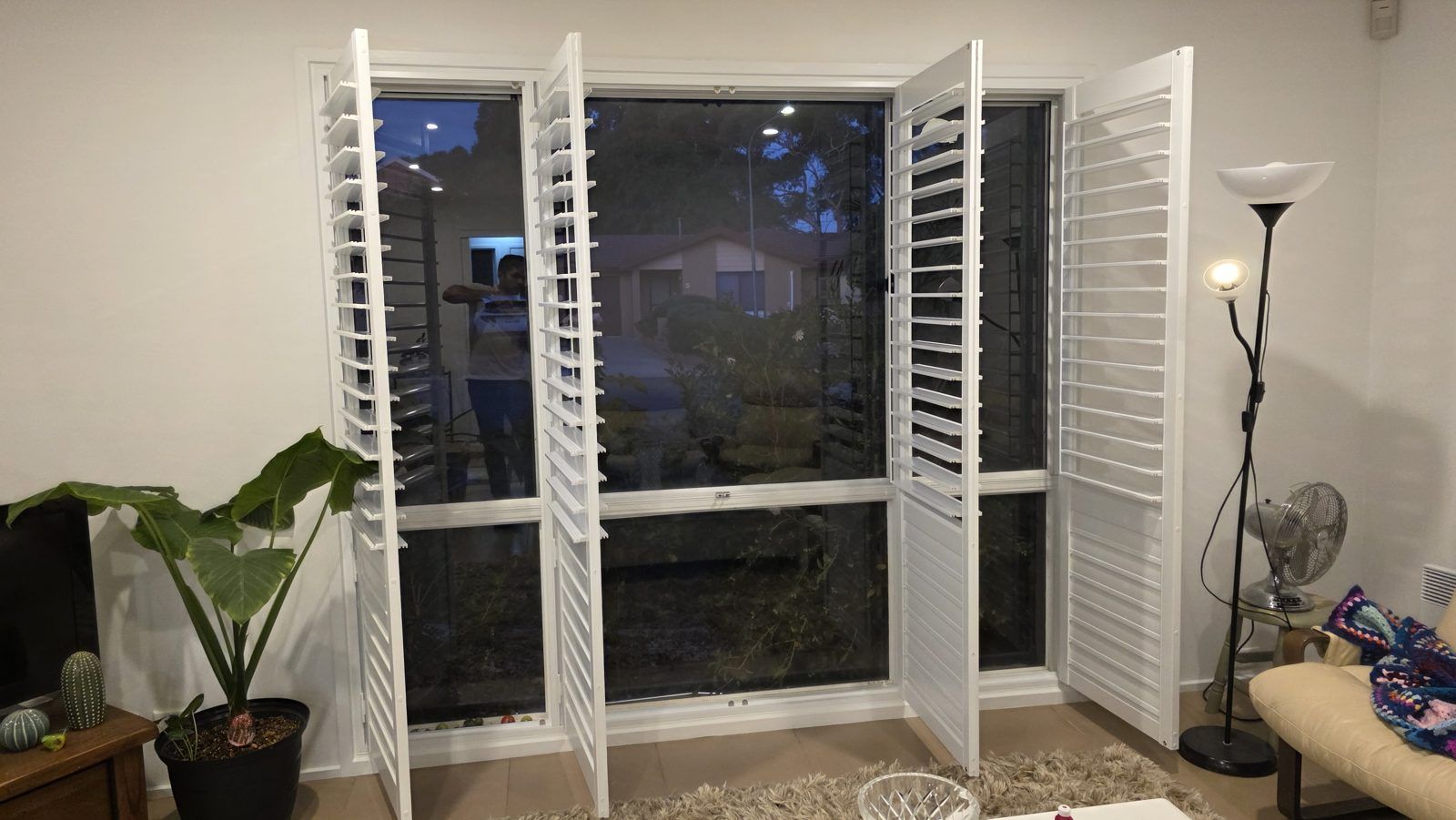 Hinged plantation shutters opened wide in an evening dining space