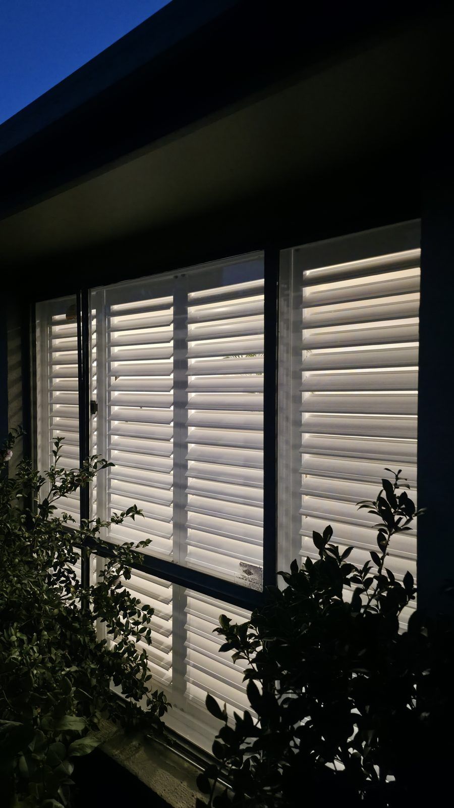 Close view of plantation shutters from outside at dusk