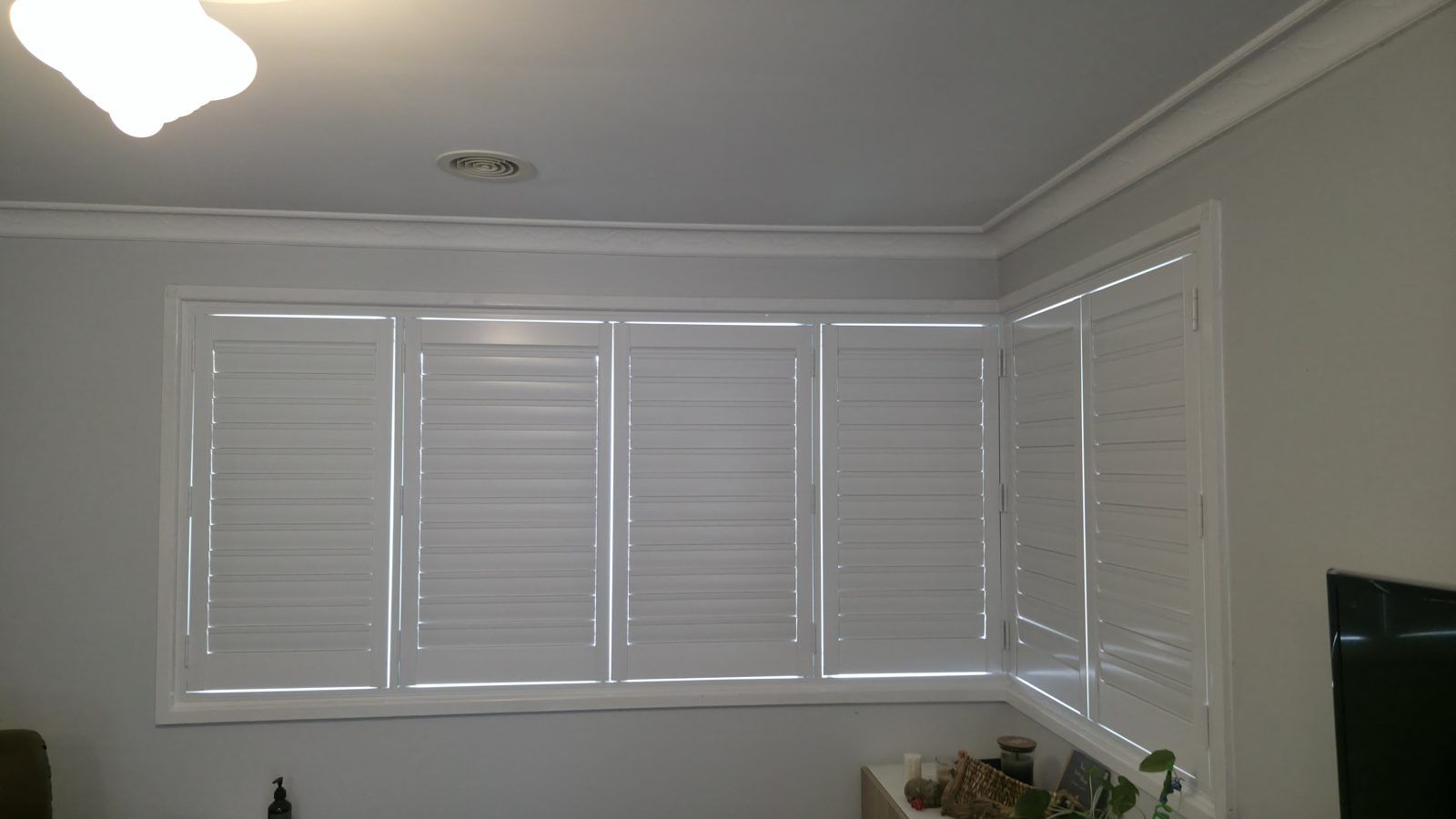 Full-width plantation shutters running across a lounge room wall