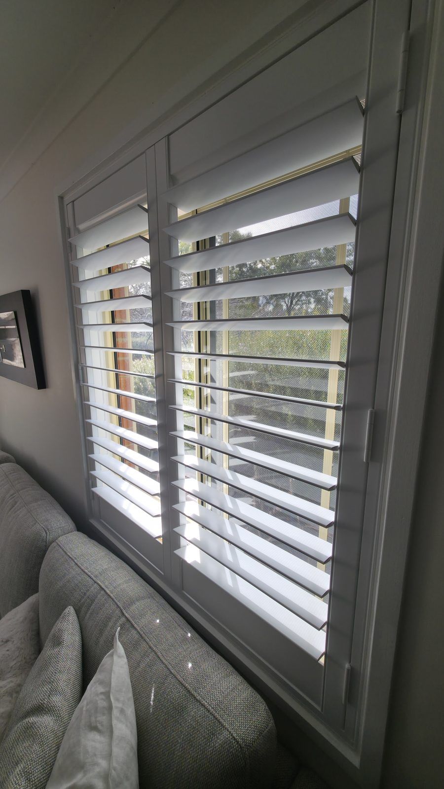 Living room corner window with wide-louvre plantation shutters