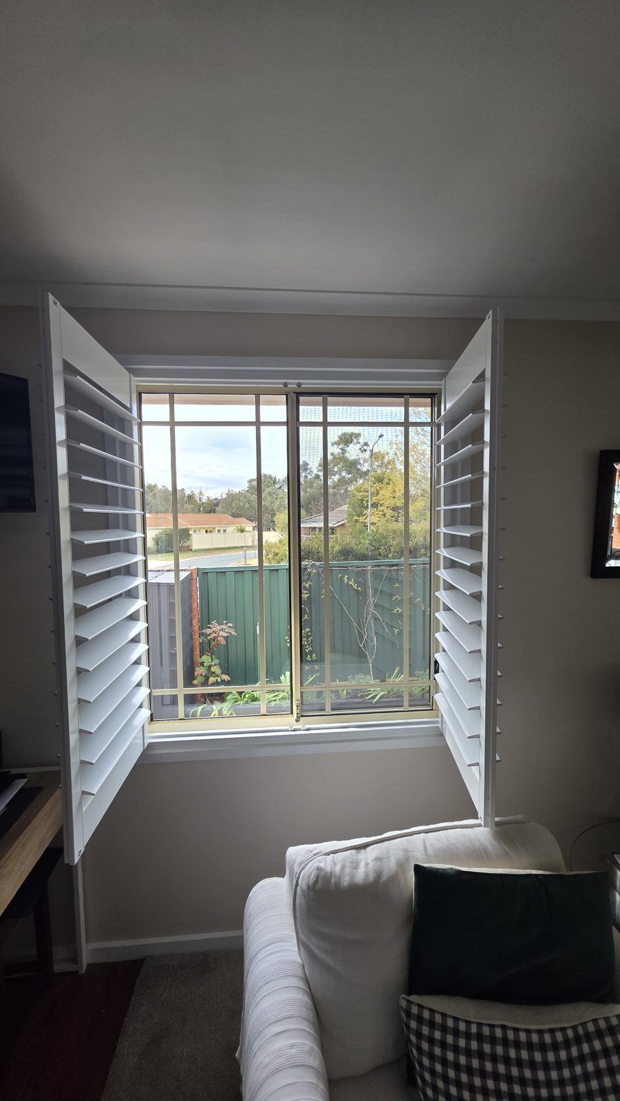 Plantation shutter panels swung open to reveal the garden view